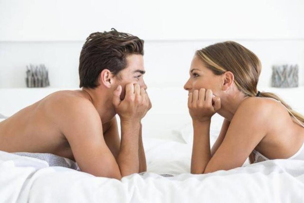 seorang wanita di tempat tidur dengan seorang lelaki dengan zakar yang diperbesar